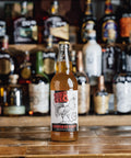 'Cornish O'cock Craft Cider' against a dark, rustic wooden table background.